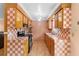 Galley kitchen featuring checkered tile backsplash, wood cabinets and stainless steel appliances at 558 Tulane Dr, Altamonte Springs, FL 32714