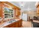 Bright kitchen featuring wood cabinets, checkered tile backsplash, double sink and view to the backyard at 558 Tulane Dr, Altamonte Springs, FL 32714