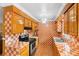 Galley kitchen featuring checkered tile backsplash, wood cabinets and stainless steel appliances at 558 Tulane Dr, Altamonte Springs, FL 32714