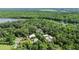 Expansive aerial view revealing the property nestled among dense trees with a river in the background at 5635 Burts Park Rd, De Leon Springs, FL 32130