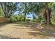 Wide backyard featuring mature trees, seating area, and lush landscaping at 5635 Burts Park Rd, De Leon Springs, FL 32130