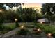 Dusk view showcasing backyard with lush landscaping and decorative lighting accents at 5635 Burts Park Rd, De Leon Springs, FL 32130