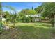 Private backyard with lush greenery, manicured lawn, and mature trees, offering a serene retreat at 5635 Burts Park Rd, De Leon Springs, FL 32130