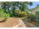 View of the backyard showing the small wooden gate and lush, mature landscaping at 5635 Burts Park Rd, De Leon Springs, FL 32130