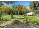 Charming backyard featuring lush landscaping, garden accents, and privacy fencing at 5635 Burts Park Rd, De Leon Springs, FL 32130