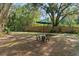 View of backyard with table set, shade umbrella and wooden privacy fence at 5635 Burts Park Rd, De Leon Springs, FL 32130