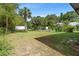 Secluded backyard offering a spacious lawn and tropical landscaping for serene outdoor living at 5635 Burts Park Rd, De Leon Springs, FL 32130