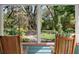 Relaxing backyard view from enclosed porch with rocking chairs and a tranquil setting at 5635 Burts Park Rd, De Leon Springs, FL 32130