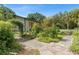 A tranquil pathway leads to an expansive barn, surrounded by meticulously kept greenery and flora at 5635 Burts Park Rd, De Leon Springs, FL 32130