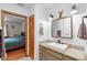 Bright bathroom featuring a modern vanity, mirror, lighting, and access to a bedroom at 5635 Burts Park Rd, De Leon Springs, FL 32130