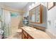 Bright bathroom with decorative mirror, shower and tub combination, plus shelving for towel storage at 5635 Burts Park Rd, De Leon Springs, FL 32130