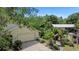 Aerial front view of home showing driveway, lush landscaping, and outbuildings at 5635 Burts Park Rd, De Leon Springs, FL 32130