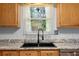 Kitchen with natural lighting, upgraded countertops, tile backsplash, and black sink at 5635 Burts Park Rd, De Leon Springs, FL 32130