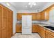 Open kitchen features a refrigerator, tile flooring, and warm oak cabinets at 5635 Burts Park Rd, De Leon Springs, FL 32130