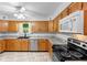 Well-lit kitchen with stainless appliances, stone countertops, and hardwood cabinets at 5635 Burts Park Rd, De Leon Springs, FL 32130