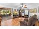 Charming living room with hardwood floors, ceiling fan, and sliding glass doors to the screened lanai at 5635 Burts Park Rd, De Leon Springs, FL 32130