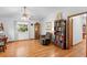 Cozy living room with a window view, ceiling fan, bookcase, and hardwood floors at 5635 Burts Park Rd, De Leon Springs, FL 32130