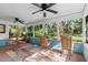Enclosed porch offers relaxing seating, fans, and stunning views of backyard landscaping at 5635 Burts Park Rd, De Leon Springs, FL 32130