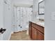 Bathroom featuring granite counters, wood cabinets, shower with tub and floral shower curtain at 600 N Boundary Ave # 118B, Deland, FL 32720