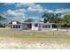 Charming single-story home with white exterior, chain-link fence, and landscaped front yard at 601 Berkshire Rd, Daytona Beach, FL 32114