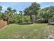 Large backyard featuring mature trees, lush green grass and perimeter fencing at 663 E Lansdowne Ave, Orange City, FL 32763