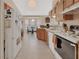 Bright kitchen with breakfast nook, wood cabinets, tile floors, and white appliances at 663 E Lansdowne Ave, Orange City, FL 32763