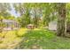 Green backyard with various sheds and buildings with tropical trees and shrubbery at 712 S Timberlane Dr, New Smyrna Beach, FL 32168