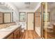 Bathroom featuring wood-look flooring, a glass shower door, and a wooden vanity at 712 S Timberlane Dr, New Smyrna Beach, FL 32168