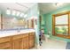 Bright bathroom featuring a wood vanity with a large mirror and a separate toilet room with a window view at 712 S Timberlane Dr, New Smyrna Beach, FL 32168