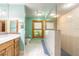 Bright bathroom featuring tiled shower, vanity with storage, and natural light from window at 712 S Timberlane Dr, New Smyrna Beach, FL 32168