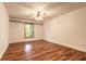 Spacious bedroom with wood floors, white walls, a ceiling fan, and a window at 712 S Timberlane Dr, New Smyrna Beach, FL 32168