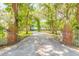 Long private drive leading to brick home surrounded by mature, moss-covered trees at 712 S Timberlane Dr, New Smyrna Beach, FL 32168