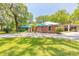 Charming home with turquoise roof and lush landscaping, a perfect blend of style and nature at 712 S Timberlane Dr, New Smyrna Beach, FL 32168