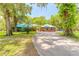 Inviting brick home with a circular driveway and lush landscaping at 712 S Timberlane Dr, New Smyrna Beach, FL 32168