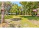 Expansive front yard with mature trees and lush greenery surrounding the property at 712 S Timberlane Dr, New Smyrna Beach, FL 32168