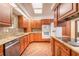 Bright kitchen with stainless steel appliances, granite countertops, brick flooring, and wood cabinets at 712 S Timberlane Dr, New Smyrna Beach, FL 32168