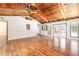 Open-concept living room with vaulted wood ceilings, hardwood floors, and access to the outdoor pool area at 712 S Timberlane Dr, New Smyrna Beach, FL 32168