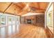 Bright living area with vaulted wood ceilings, a cozy brick fireplace, and views of the pool at 712 S Timberlane Dr, New Smyrna Beach, FL 32168