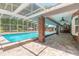 Screened-in pool and pool-side patio with brick pillars and ceiling fans at 712 S Timberlane Dr, New Smyrna Beach, FL 32168