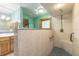 Walk-in shower featuring tiled walls and a built-in seat next to the bathroom's vanity at 712 S Timberlane Dr, New Smyrna Beach, FL 32168