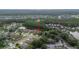 The aerial view showcases a pond-adjacent home in a lush neighborhood, surrounded by trees and other residences. Arrow indicates property at 723 Oakwater Ln, Port Orange, FL 32128