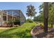 A spacious backyard featuring lush greenery, a screened-in lanai, and mature landscaping offering a private outdoor space at 723 Oakwater Ln, Port Orange, FL 32128