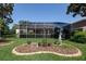 Landscaped backyard with green grass, shrubbery and a screened-in patio at 723 Oakwater Ln, Port Orange, FL 32128