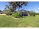 Landscaped backyard with green grass, shrubbery and a screened-in patio at 723 Oakwater Ln, Port Orange, FL 32128