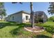 View of a spacious backyard with lush grass, a mature tree, and a screened-in lanai for outdoor enjoyment at 723 Oakwater Ln, Port Orange, FL 32128