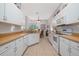 Bright kitchen features white cabinetry, tile flooring, and a view into the adjacent dining area at 723 Oakwater Ln, Port Orange, FL 32128