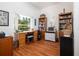 Home office featuring wood desk and cabinets, hardwood floors and a bright window at 723 Oakwater Ln, Port Orange, FL 32128