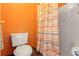 Cozy bathroom featuring an orange wall, toilet, and shower with colorful curtain at 809 Brightview Dr, Lake Mary, FL 32746