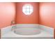 Close-up of a bathtub with white tile surround and an octagonal window above at 809 Brightview Dr, Lake Mary, FL 32746
