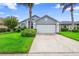 Charming single-story home with a well-manicured lawn, palm trees, and an attached two-car garage at 809 Brightview Dr, Lake Mary, FL 32746
